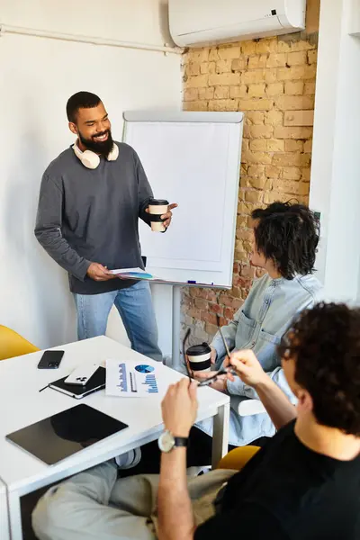 A man leads an interactive team discussion as colleagues listen attentively to his ideas. — Stock Photo