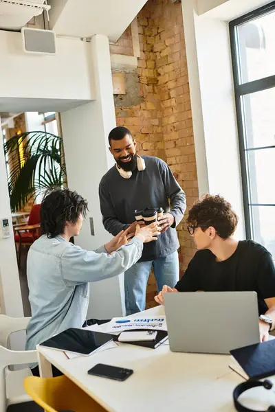 Colegas comparten ideas mientras disfrutan de bebidas en un espacio de trabajo amplio y luminoso lleno de energía. - foto de stock