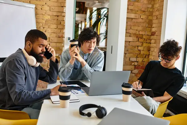 Three professionals share ideas over coffee in a productive session in a cozy office. — Stock Photo