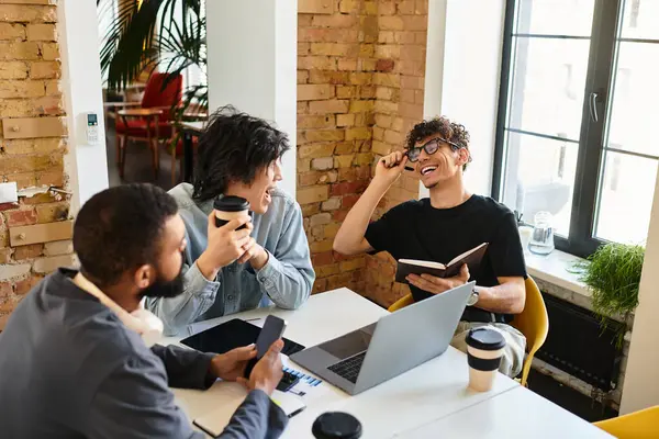 Three professionals engage in a lively discussion while enjoying coffee in a modern office setting. — Stock Photo