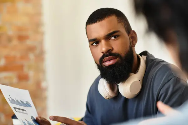 Colleagues share insights while reviewing graphs in a bright workspace. — Stock Photo