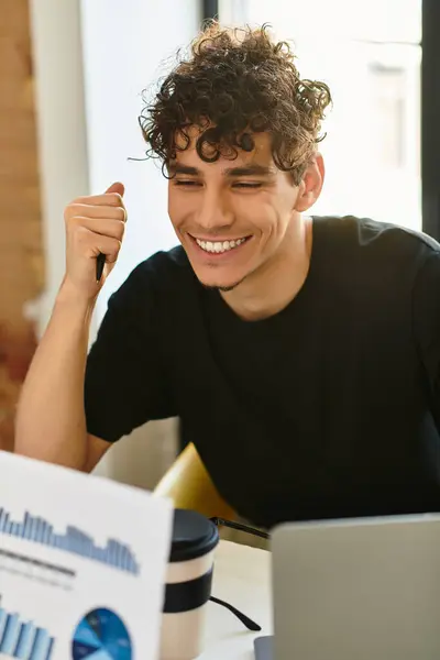 Jeune homme célèbre un moment réussi d'analyse de données dans un bureau moderne. — Photo de stock