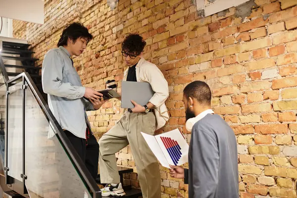 Team members engage in a brainstorming session while reviewing documents on a staircase. — Stock Photo