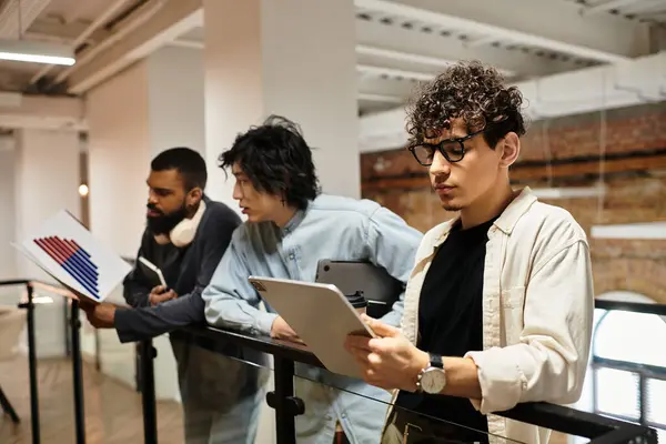 Young adults engage in a creative brainstorming session while reviewing documents in an office. — Stock Photo