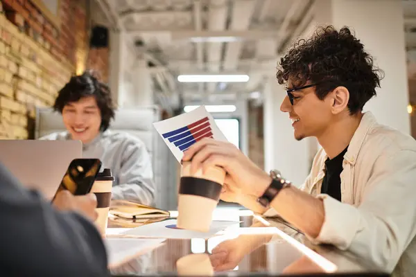 Colleagues collaborate at a bright office table, sharing ideas over coffee and laptops. — Stock Photo