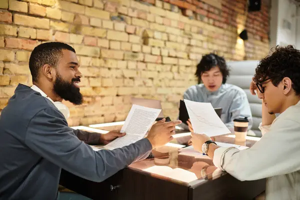 Three professionals engage in a collaborative discussion, reviewing documents and sharing ideas. — Stock Photo