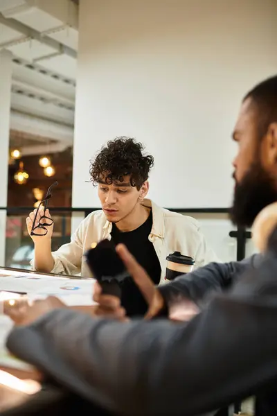 Zwei Fachleute diskutieren an einem zeitgenössischen Arbeitsplatz über Materialien. — Stockfoto