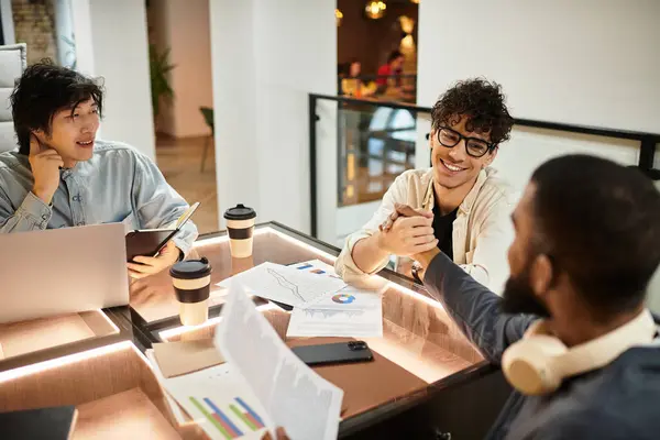 Three colleagues chat animatedly, sharing ideas over coffee at a chic office table. — Stock Photo