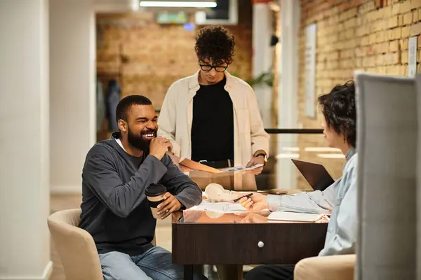 Team members brainstorm over coffee in a bright, modern workspace with natural light. — Stock Photo