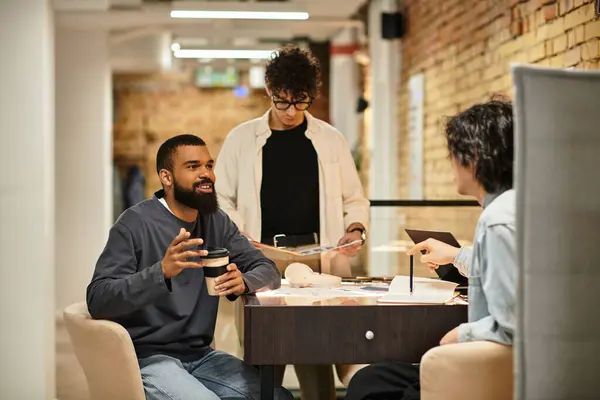 Three colleagues chat lively while collaborating on a project in a chic office. — Stock Photo