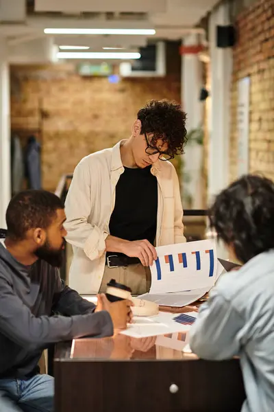 Team members engage in productive discussions while reviewing project documents and charts. — Stock Photo