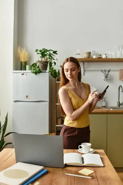 Una giovane donna con i capelli lunghi usa il suo smartphone su un tavolo da cucina pieno di piante. — Foto stock