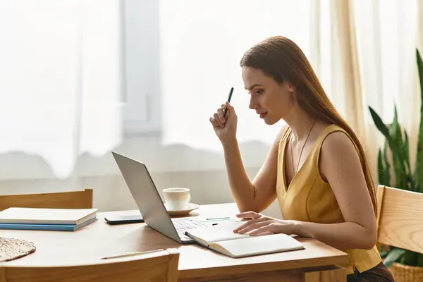 Focused young woman pens her thoughts while enjoying a warm drink in a sunlit room. — Stock Photo