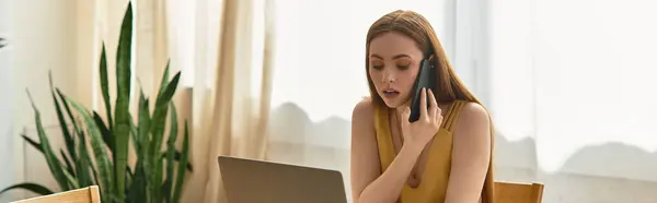 Young woman interacts on the phone, connecting with someone while focused on her laptop tasks. — Stock Photo
