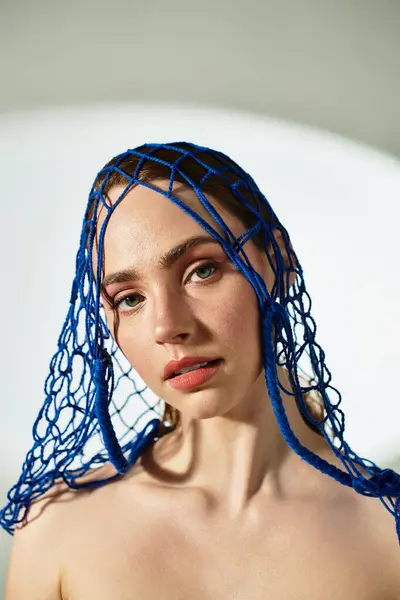 A stunning young woman flaunts elegant fashion with a striking blue headdress, exuding confidence. — Stock Photo