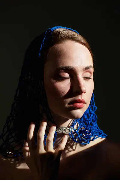 A serene young woman in a striking blue headscarf reflects with her eyes closed. — Stock Photo