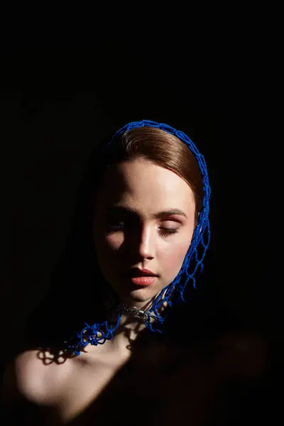 A young woman in a blue headscarf poses gracefully, her serene expression captivating all. — Stock Photo
