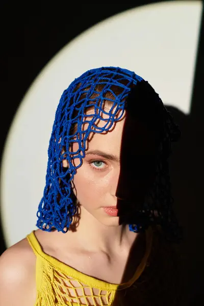Young woman displays a vibrant headpiece, highlighted by striking shadows and light. — Stock Photo