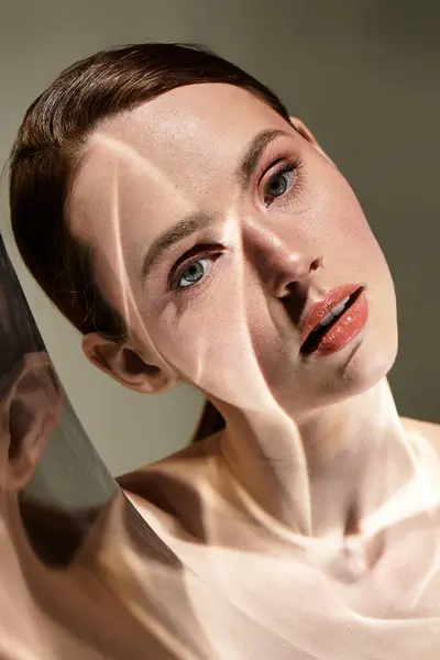 A young woman poses gracefully, bathed in soft light that casts gentle reflections. — Stock Photo