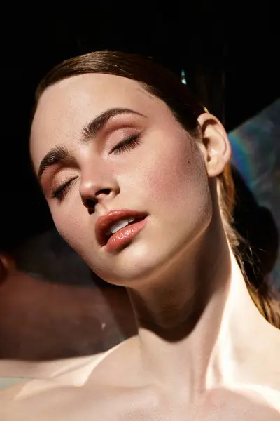 Une jeune femme se prélasse dans une lumière douce, son expression calme rayonnant de tranquillité. — Photo de stock