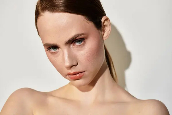 A stunning young woman gazes confidently, adorned with natural makeup showcasing her beauty. — Stock Photo