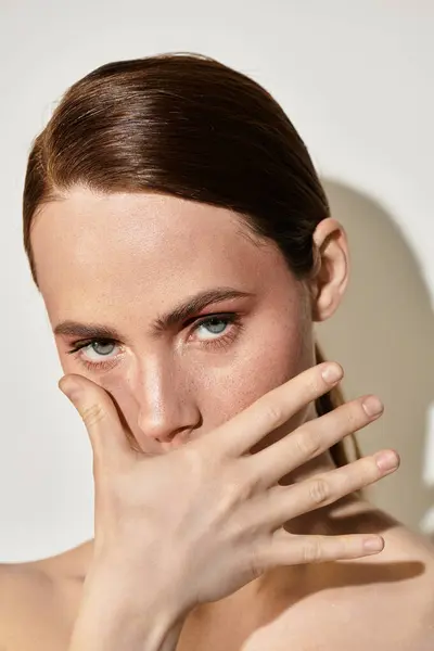 A young woman poses with her hand on her face, exuding elegance and intrigue. — Stock Photo