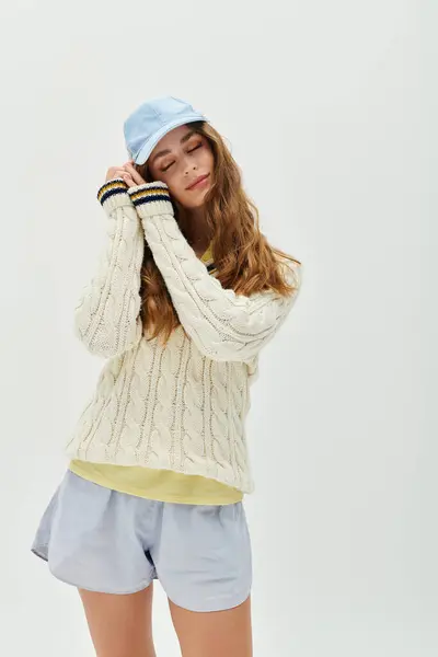 A young beautiful woman with long hair relaxes in a cozy sweater and hat, embracing the calm. — Stock Photo
