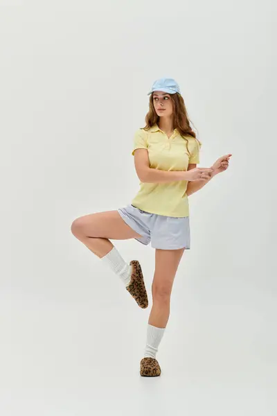 A young beautiful woman showcases her playful spirit with a lively pose, dressed in casual colors. — Stock Photo