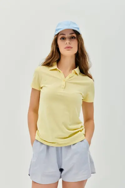 Giovane bella donna vestita con una camicia gialla brillante e pantaloncini irradia eleganza casual. — Foto stock