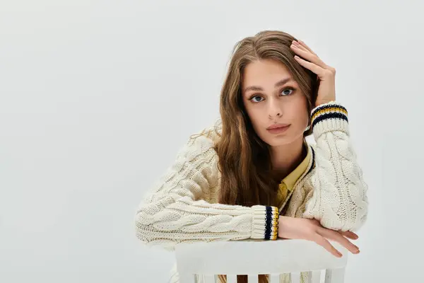 A lovely young woman with long hair rests her chin on her hand, radiating elegance. — Stock Photo