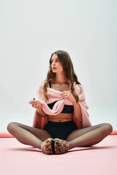 Beautiful young woman embraces comfort while posing gracefully in a vibrant indoor environment. — Stock Photo