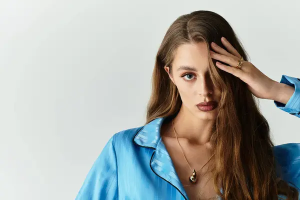 Jovem mulher elegante com cabelo fluindo exibe seu sentido de moda única no estúdio. — Fotografia de Stock