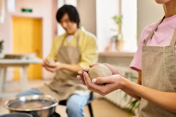 Young couple enjoys working with clay in a pottery studio, sharing smiles and artistic moments. — Stock Photo