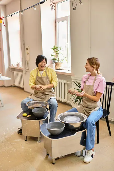 A young couple enjoys crafting pottery together in a cozy and artistic studio atmosphere. — Stock Photo