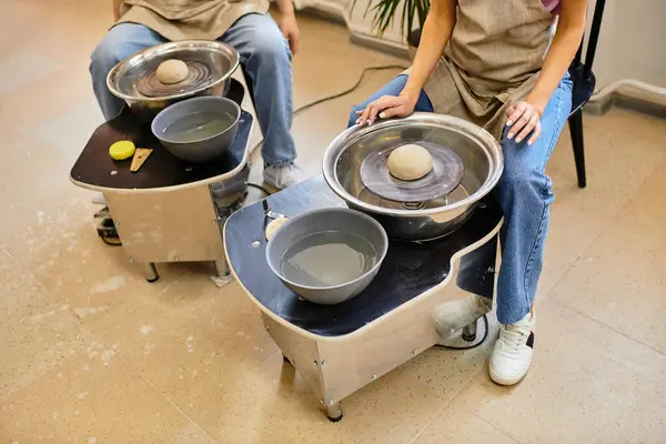 A young couple engages in pottery making, shaping clay with love in a vibrant art studio. — Stock Photo