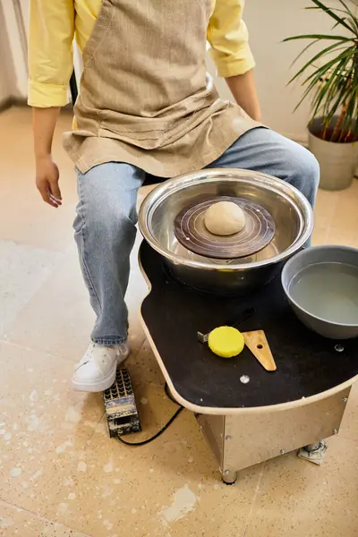 Artisan molds clay on a potters wheel in a well lit pottery studio brimming with creativity. — Stock Photo