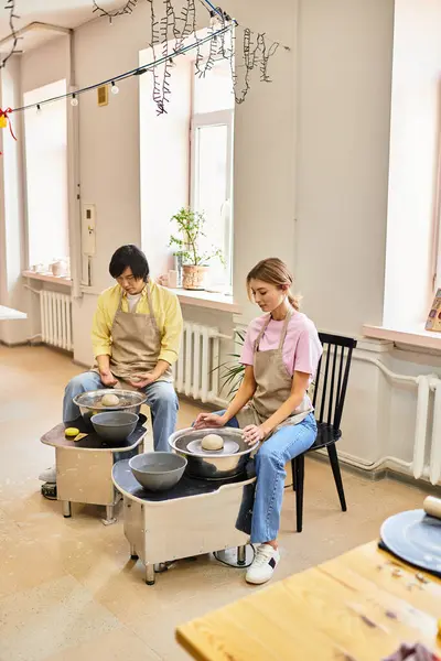 A young couple enjoys their time at a pottery studio, crafting beautiful clay designs together. — Stock Photo