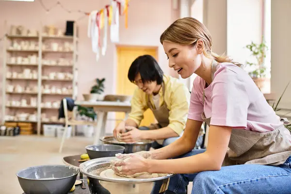 A young couple enjoys pottery making, laughing and crafting their art in a warm, inviting studio. — Stock Photo