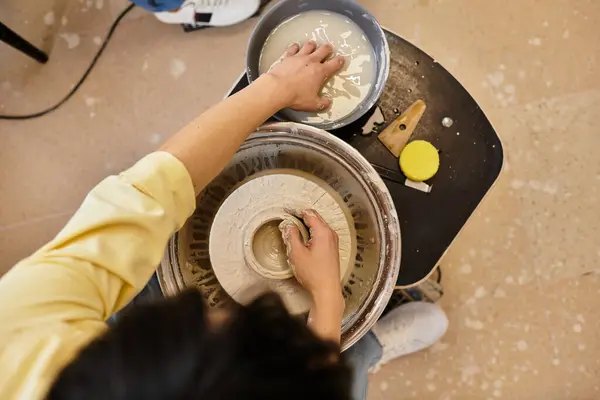 Hands skillfully shape wet clay on the pottery wheel while vibrant colors fill the studio. — Stock Photo