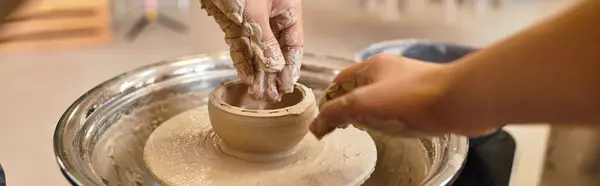 Hands skillfully shape clay on a wheel, crafting pottery in a bright, inviting studio. — Stock Photo