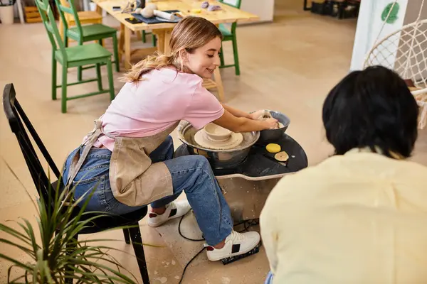 A young couple enjoys a joyful moment making pottery in a cozy, creative art studio. — Stock Photo