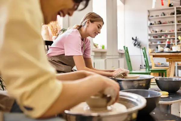 Young couple joyfully shaping clay in a pottery studio, celebrating creativity and connection. — Stock Photo