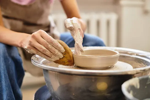 Hands skillfully shape clay into a beautiful pottery piece in a bright, inviting studio. — Stock Photo