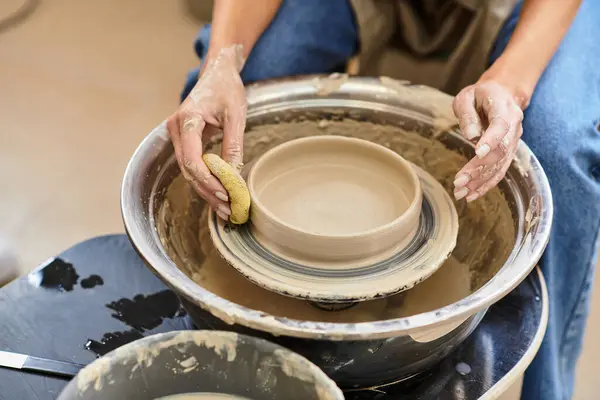 In a vibrant pottery studio, skilled hands shape soft clay on a wheel into beautiful pieces. — Stock Photo