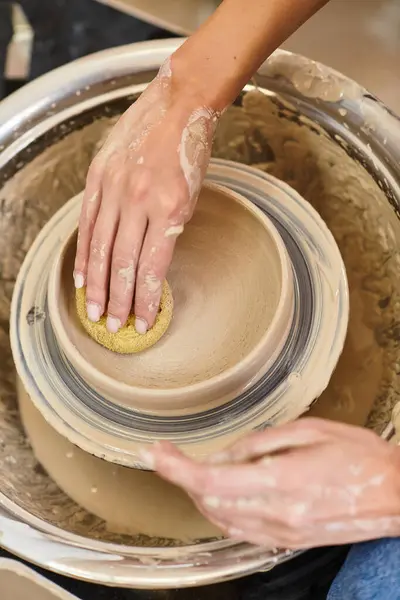 Hands skillfully shape and refine a pottery creation in an artisan studio filled with inspiration. — Stock Photo