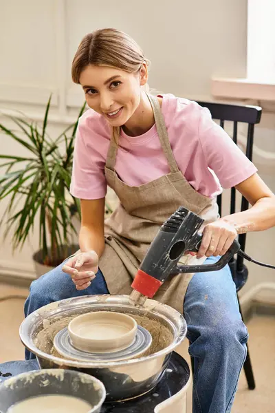 An artisan shapes a bowl on a pottery wheel, surrounded by vibrant art supplies. — Stock Photo