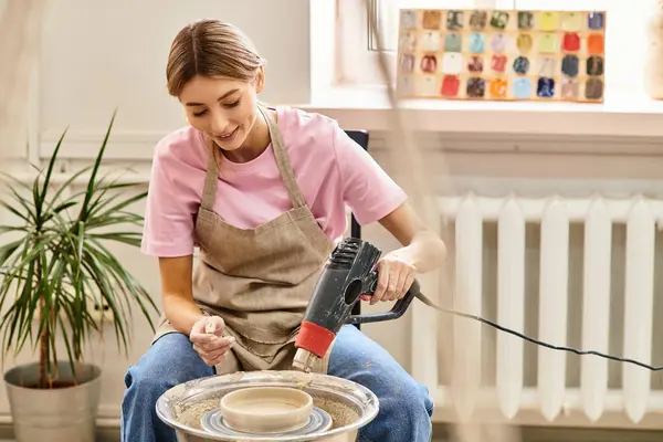 Um jovem artista habilmente forma argila em uma roda de cerâmica em um estúdio brilhante e colorido. — Fotografia de Stock