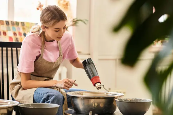 Focused artisan shapes clay with a creative spirit in a lively pottery studio, surrounded by art. — Stock Photo