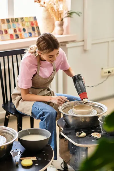 An artist shapes clay on a wheel in a vibrant, creative pottery studio. — Stock Photo