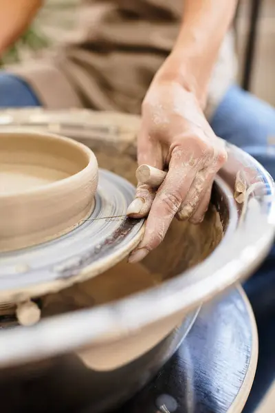 Hands skillfully shaping clay on a potters wheel in a bright, inviting studio. — Stock Photo